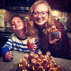 A young woman and boy holdingNutter Butter Turkey Cupcakes