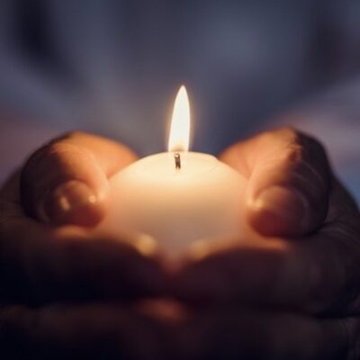 hands holding lit candle