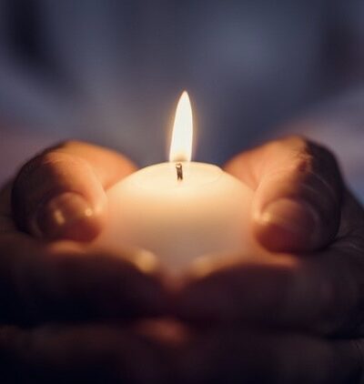 hands holding lit candle