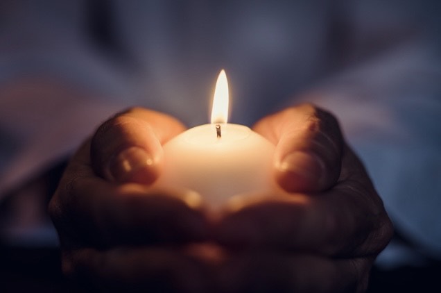 hands holding lit candle